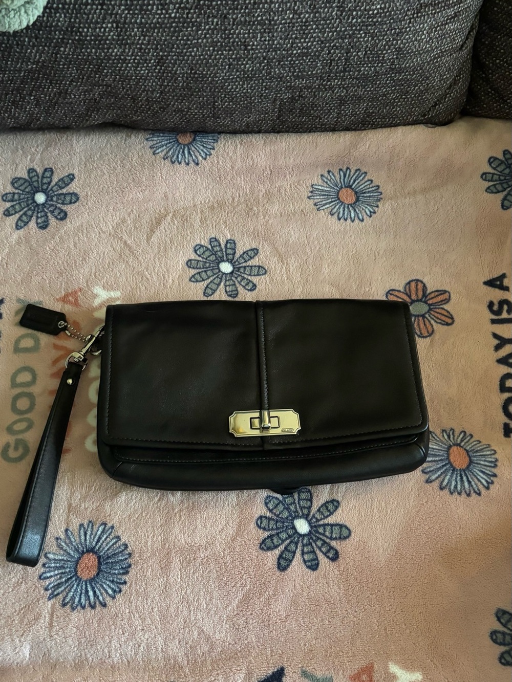 Coach Chelsea wristlet clutch featuring a turn-lock closure and a wrist strap.